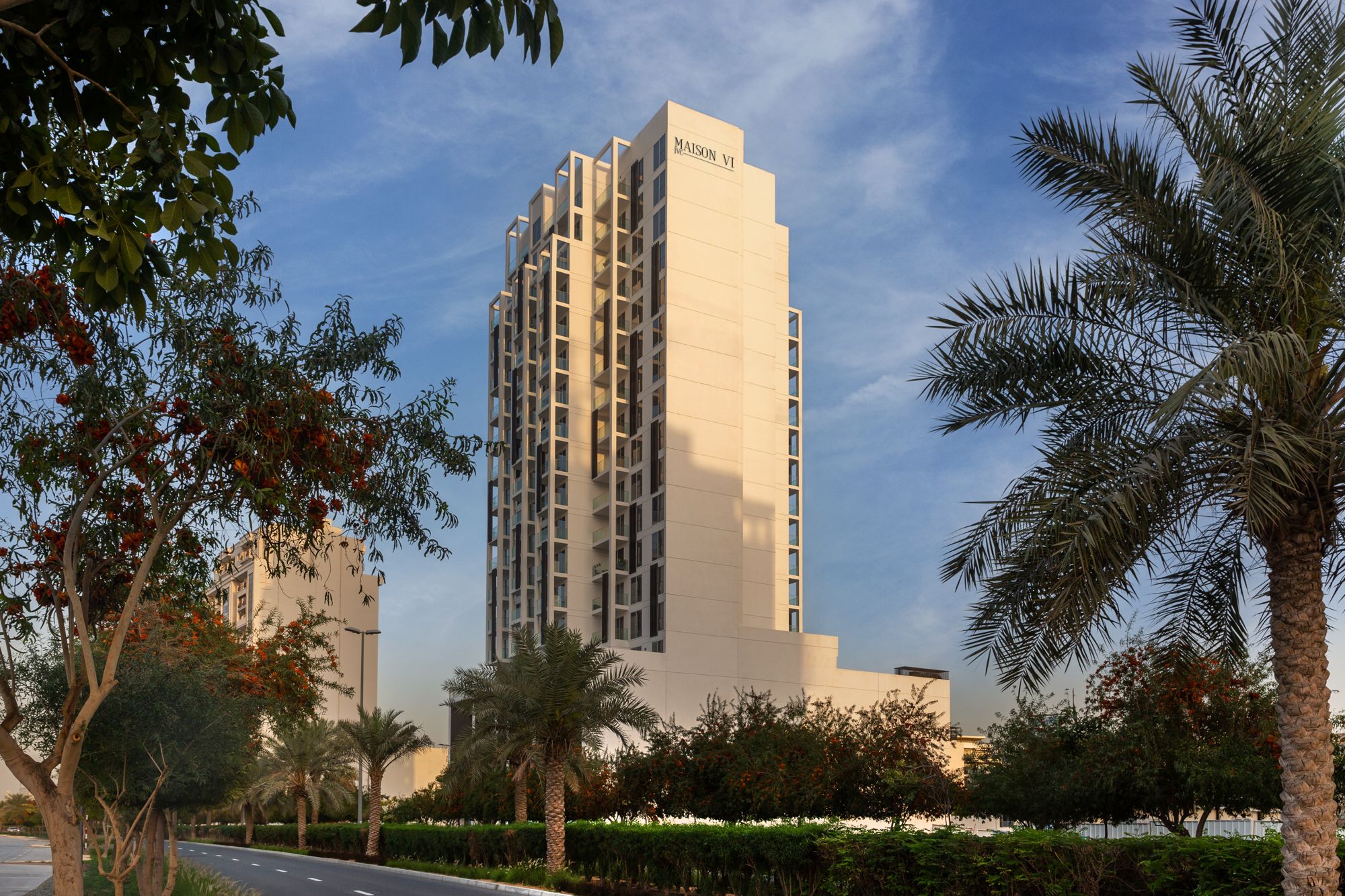 Maison VI Residences tower in Jumeirah Village Circle, framed by palm trees