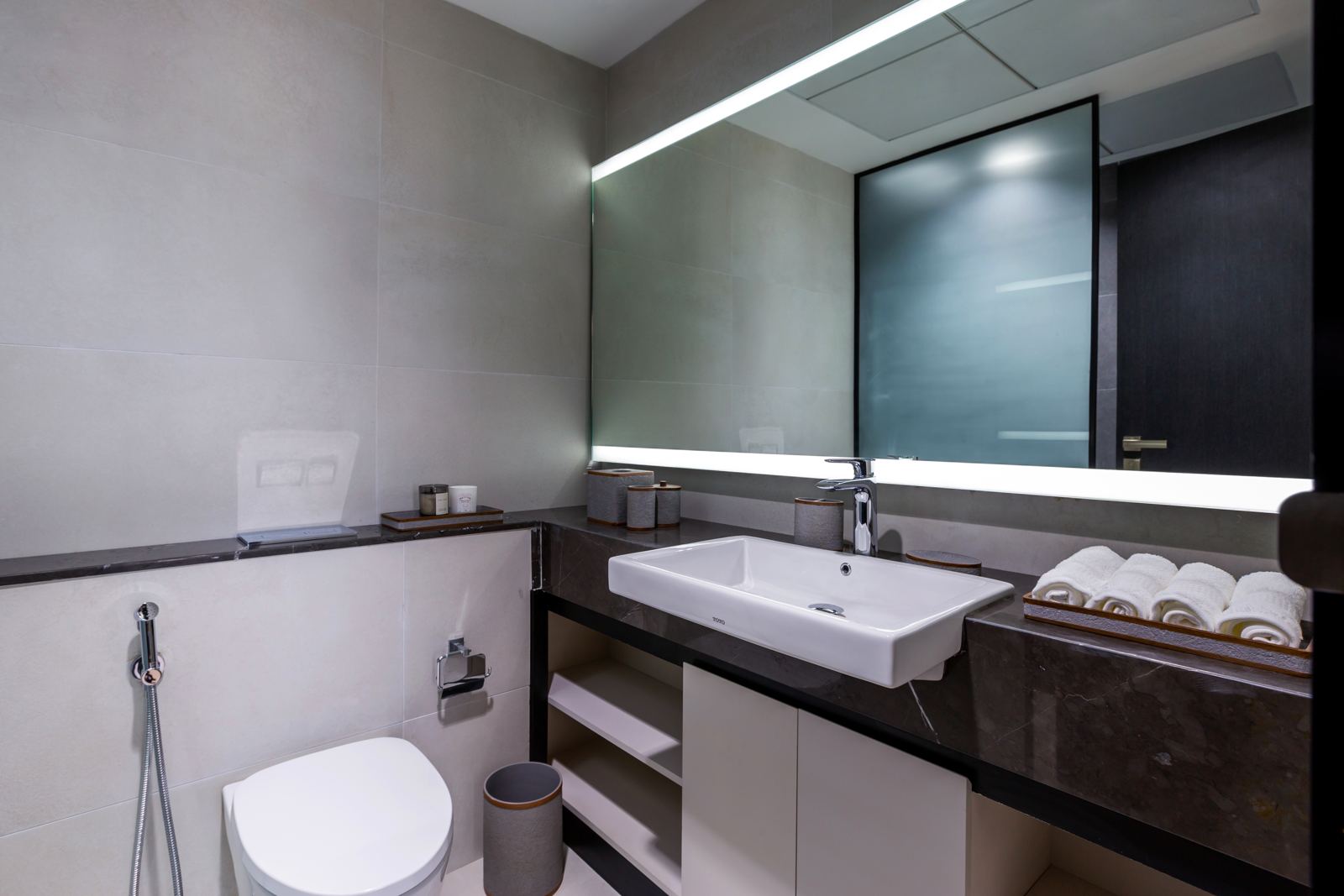 Bathroom with backlit mirror and stone vanity