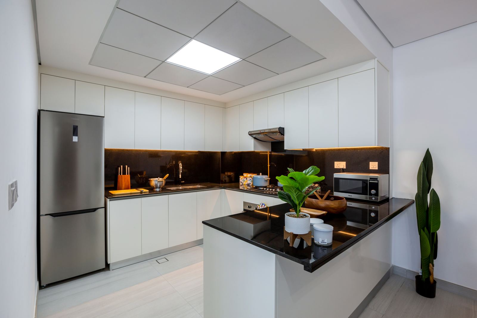 White kitchen with black worktops and Teka appliances
