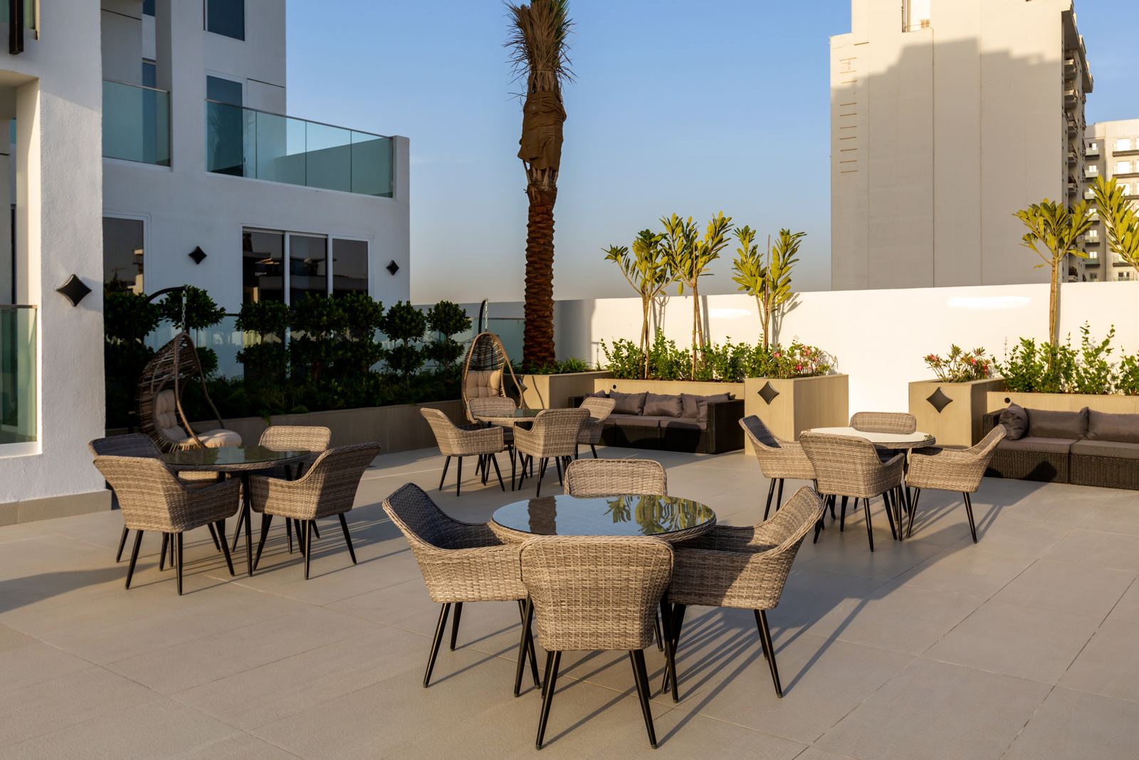 Podium terrace with rattan dining sets, lounge seating and planters